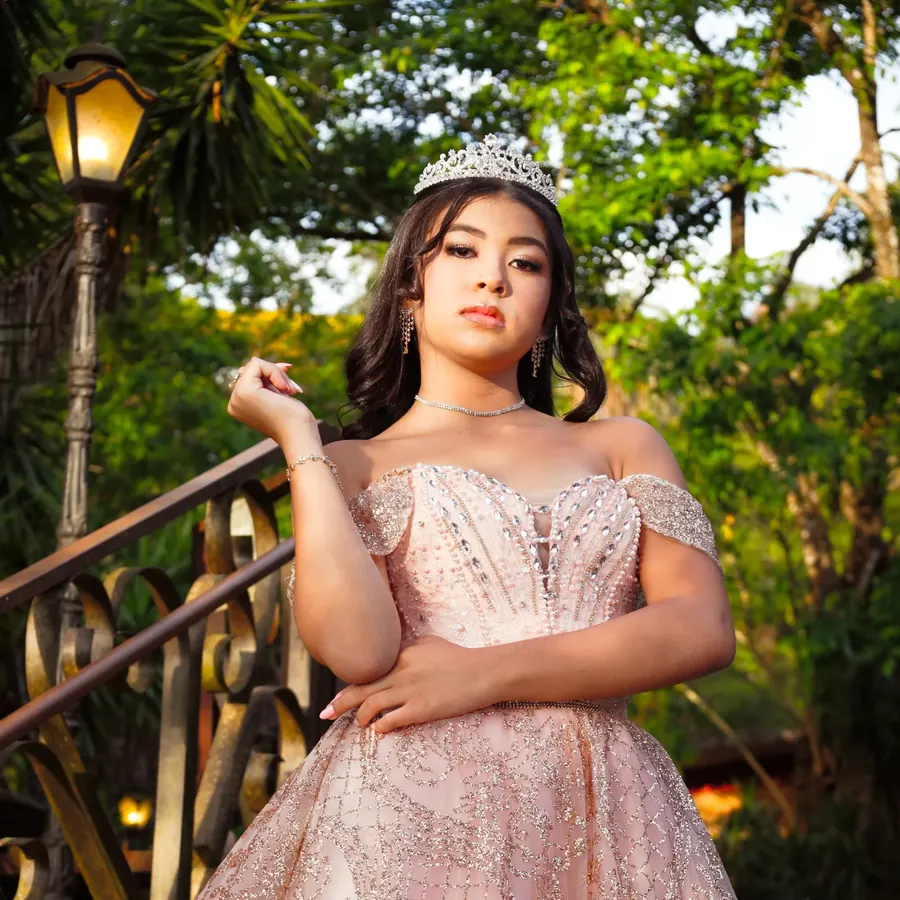 Debutante de vestido rosa e tiara no jardim